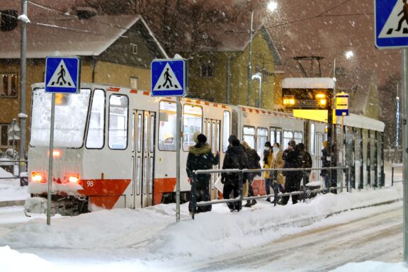 Tram station with people in Estonia in winter time.
