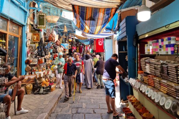 Bustling Market Street in Tunis, Tunisia with Colorful Shops and Shoppers People walking through a market in Tunis, Tunisia, one of the safest countries in Africa.