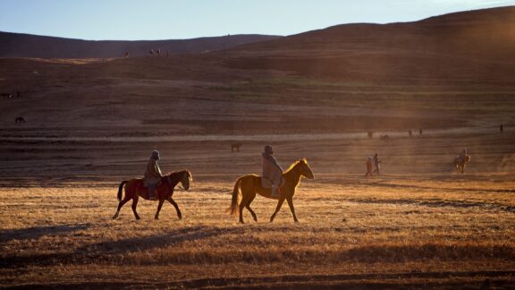 Two Basotho horsemen ride through the highlands of Lesotho.