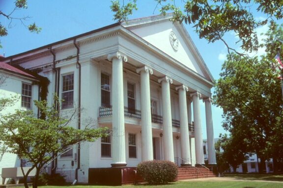 The front of the Perry County Courthouse in Marion, Alabama can be seen on a sunny day.