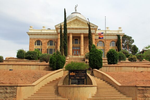 A low-angle view of the stairs leading up to the facade of the Santa Cruz County Courthouse in Nogales, Arizona.