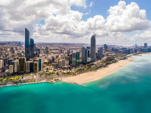 Skyscrapers and city buildings stand next to a beach in Abu Dhabi, the safest city in the world. 