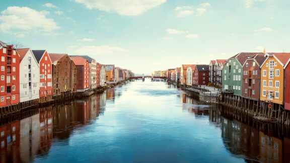 Colorful wooden houses line the water in Trondheim, Norway.