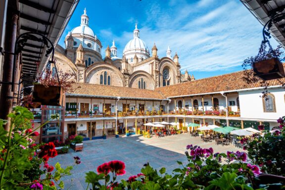 Vibrant Plaza with Cafes in Front of the Imposing Cuenca Cathedral, Ecuador A view of the Cathedral of the Immaculate Conception in Cuenca, Ecuador on a sunny day.