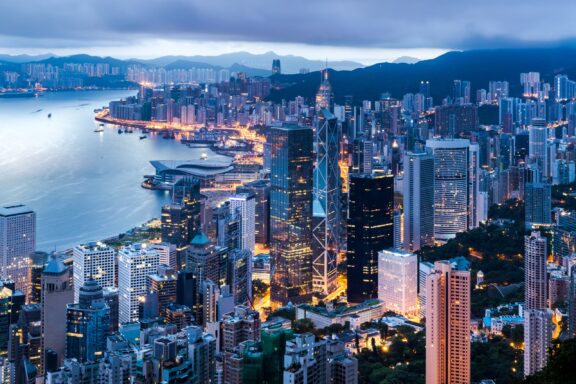 A view of Hong Kong next to the water at dusk. 