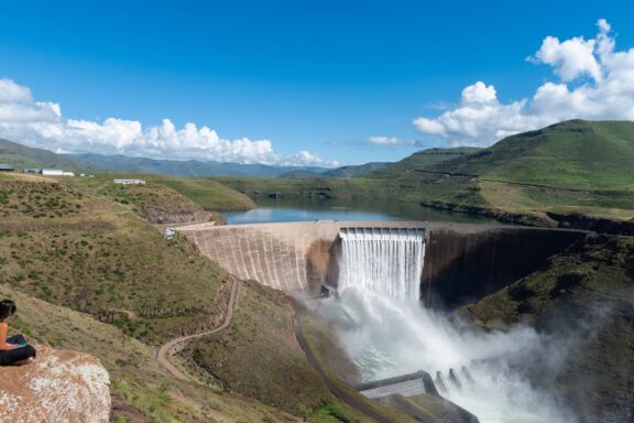 Overflowing Dam in Lush Green Landscape The Katse Dam, one of the largest of its kind in Africa
