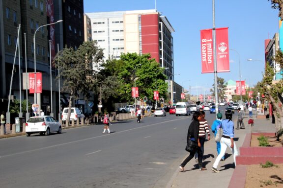 Pedestrians and Traffic on a Sunny Day in Maseru City Street Locals commuting on a busy commercial street in Maseru
