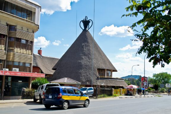 Thatched Roof Building and Car on Street The Mokorotlo building in Maseru
