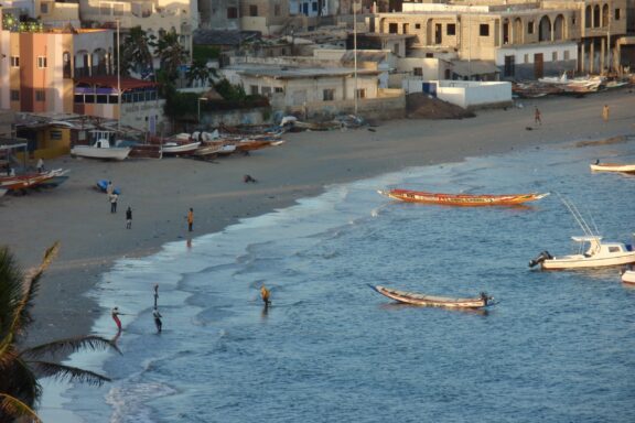 Coastal View of N'Gor Beach with Boats and People N'Gor Beach at sunset