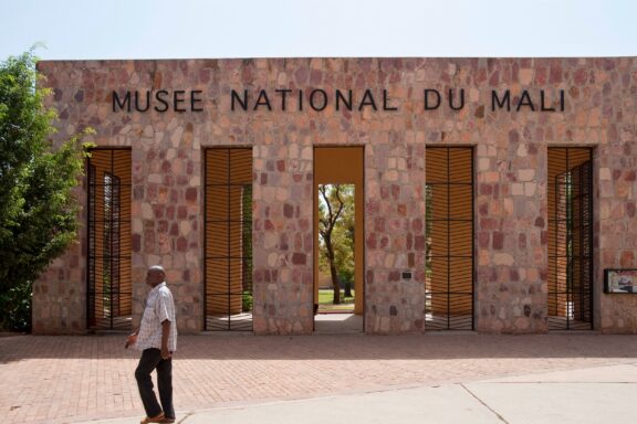 Person Walking by the National Museum of Mali Bamako mali circa february 2012: a man walks past