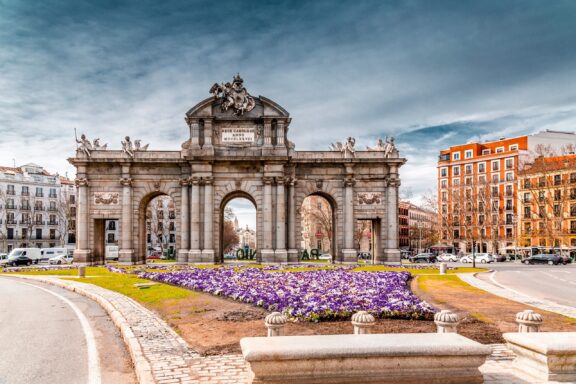 Alcala Gate in Madrid with Flower Beds The Puerta de Alcalá, commissioned by King Carlos III