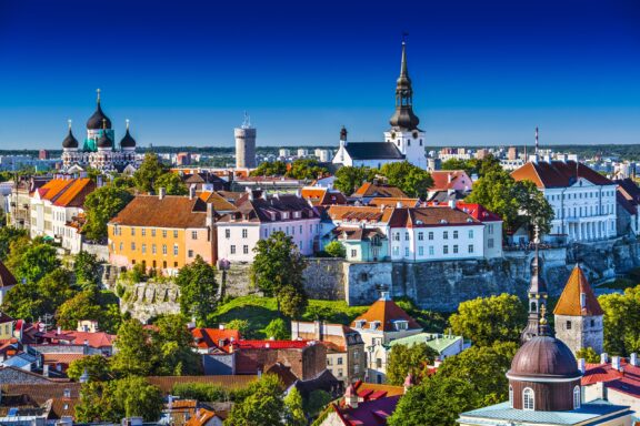 The Old Town of Tallinn, Estonia shines in the sun against a blue sky. 