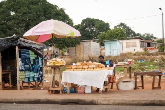 Ivorian african woman with her daughter selling bread in the