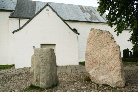 The two Jelling Stones sit outside Jellinch Church in Denmark.