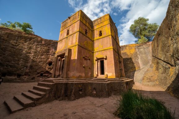 A low-angle view of a rock-hewn church in Lalibela, Ethiopia.