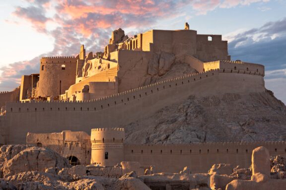 The sun shines on the walls of the Bam Citadel in Iran just before sunset. 