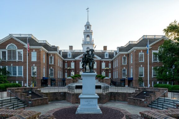 A statue of three men stands outside the capitol building in Dover, Delaware.