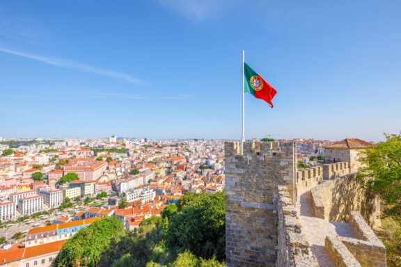 A Portuguese flag flies from a tower on São Jorge Castle in Lisbon, Portugal.