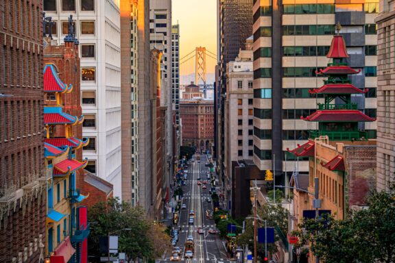 The Golden Gate Bridge can be seen between buildings from San Francisco’s financial district.