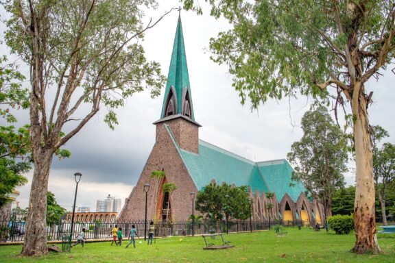 Church with Green Roof and Spire Amidst Trees Basilique sainte anne in city center of brazzaville congo republic
