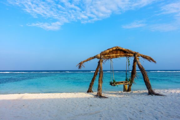 Tropical Beach with Wooden Swing Hulhumalé Beach, an artificial beach planned as an urban extension to alleviate Male’s population density