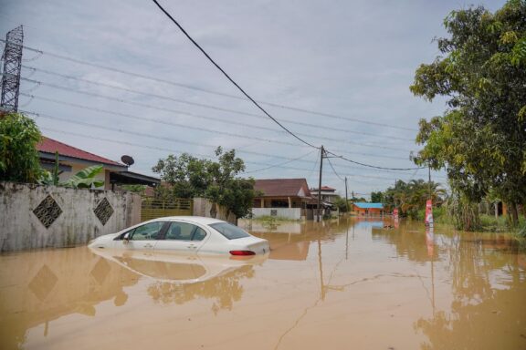 Flooded Street with Submerged Car Flooded streets in Kuala Lumpur, common sight during monsoon season