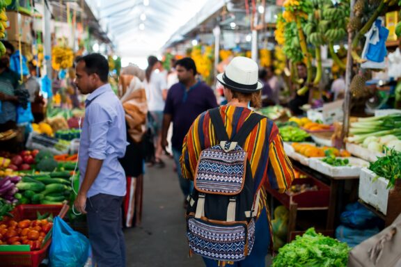 Man with Backpack at Busy Food Market Local and tourists shop in the bustling food markets
