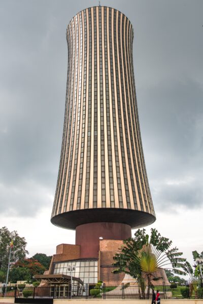 Tall cylindrical skyscraper against cloudy sky The Nabemba Tower, also known as Elf Tower, the tallest building in Brazzaville