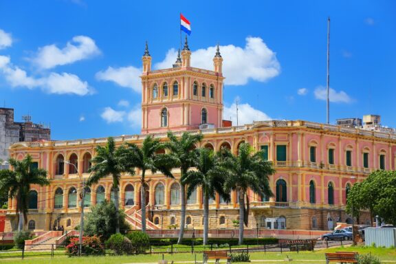 Pink Historical Building with Flag Under Blue Sky Palacio de los López, a neoclassical building that dates back to the mid-19th century