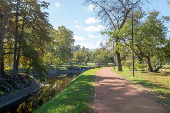 Pathway in a Sunny Park with Trees and Stream Parque Prado, one of Montevideo's largest parks