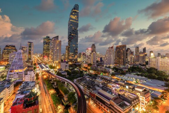 Dusk View of Bangkok Skyline with Skyscrapers and Train Track Silom District, a bustling neighborhood located in the heart of Bangkok