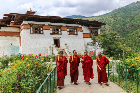 Monks Walking in Front of Simtokha Dzong, Bhutan Monks at Simtokha Dzong in Thimphu, Bhutan, a fortress dating back to 1629