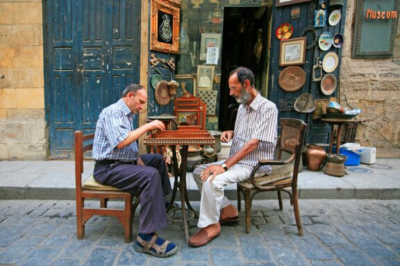 Two men sit outside at a cafe and play Backgammon in downtown Cairo, Egypt.