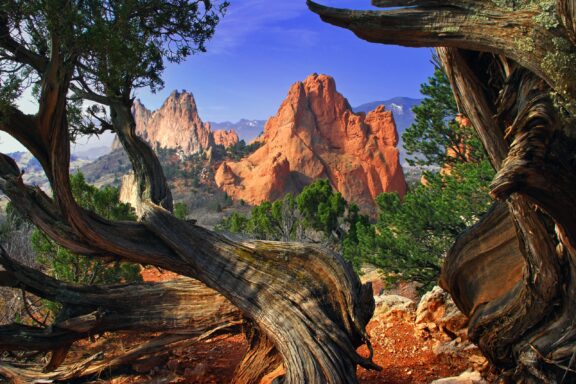 The South Gateway Rock formation can be seen from a distance through the trees in Colorado.