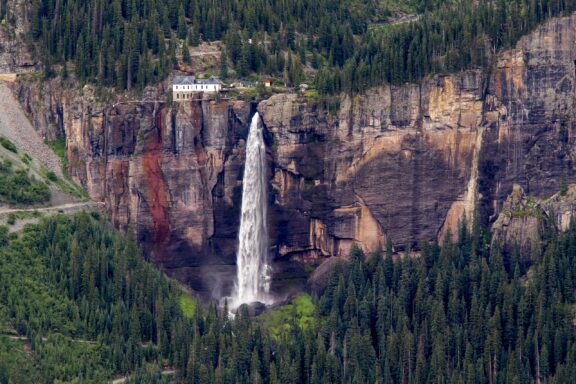 Secluded Building Overlooking a Majestic Waterfall in the San Juan Mountains of Telluride, Colorado Bridal Veil Falls can be seen from a distance outside Telluride, Colorado.