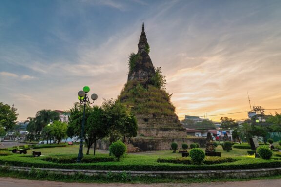 Stupa at Dusk with Greenery That Dam Stupa, known as the "Black Stupa," is intertwined with local legends and cultural mystique