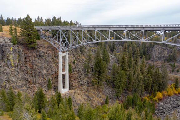 A large bridge spans a valley under a cloud sky in Clark County, Idaho.