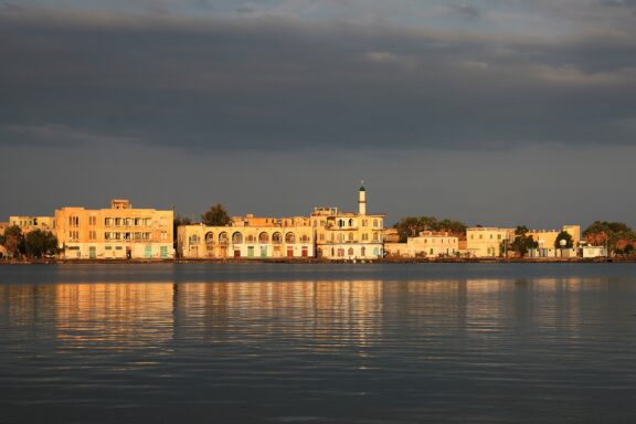 Buildings line the water under a dark sky in Eritrea’s port of Massawa.