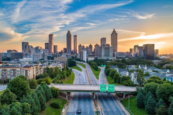 Downtown Atlanta Skyline at Sunset with Interstate Highway in Foreground Aerial view of highways leading to Atlanta, Georgia, the seat of Fulton County.