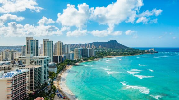 An aerial view of Waikiki Beach in Honolulu with Diamond Head Crater in the distance.