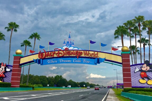 An entrance sign that says “Where Dreams Come True” spans the road leading to Walt Disney World near Orlando, Florida. 