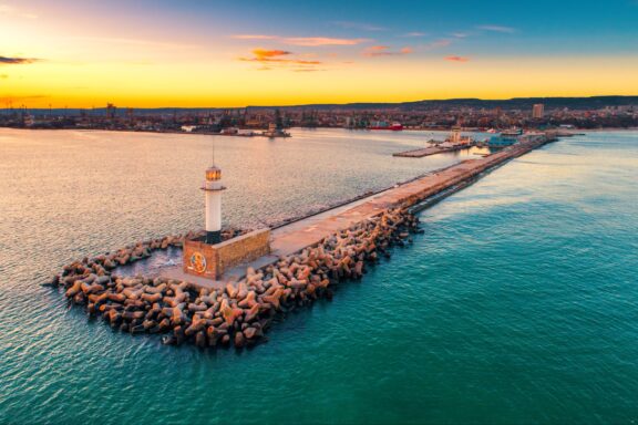 An aerial view of the Varna Seaport Lighthouse extending into the Black Sea from the Bulgarian coast.