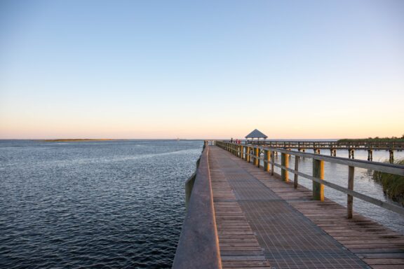 Serene Waterfront Boardwalk at Sunset in Apalachicola A dock extends into the sea at dusk in Apalachicola, Florida.