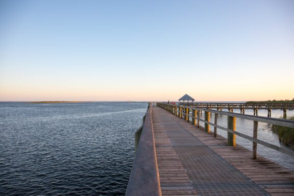 A dock extends into the sea at dusk in Apalachicola, Florida.