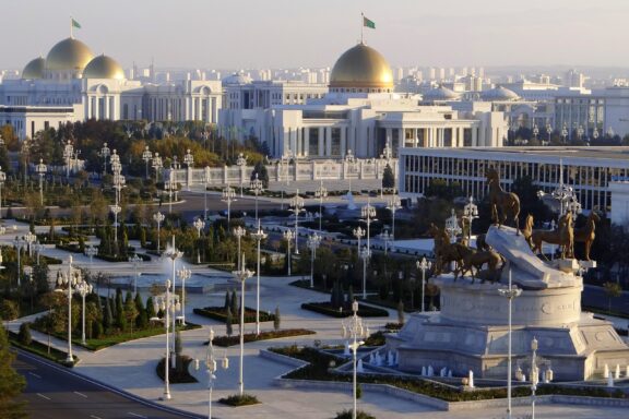 White marble buildings with golden domes shine in the sun in Ashgabat, Turkmenistan.