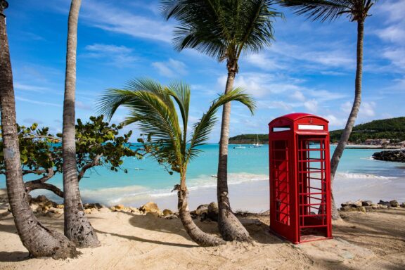 Red Phone Booth on Tropical Beach Dickenson Bay, one of the most popular beaches in Antigua