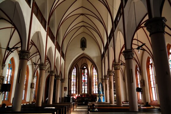 Interior View of Lomé Cathedral with Arched Ceilings and Stained Glass Windows Cathedral of Lomé, built during the early 20th century