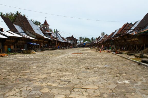 A low-angle view of a row of traditional houses on Nias Island in Northern Sumatra, Indonesia.