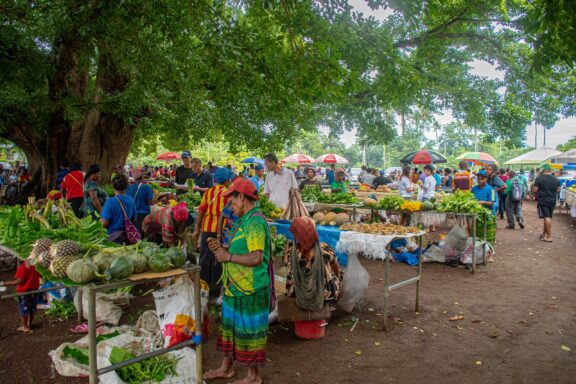 Bustling Outdoor Market Scene with Colorful Stalls and Shoppers Merchants at Sunday Market in Port Moresby
