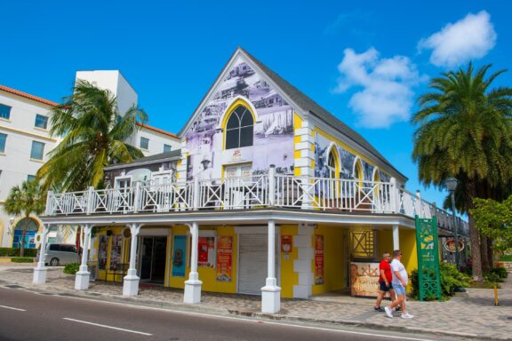 Colorful Museum Building with Palm Trees and Visitors Pompey Museum, named after a slave who lived on the Exuma Islands